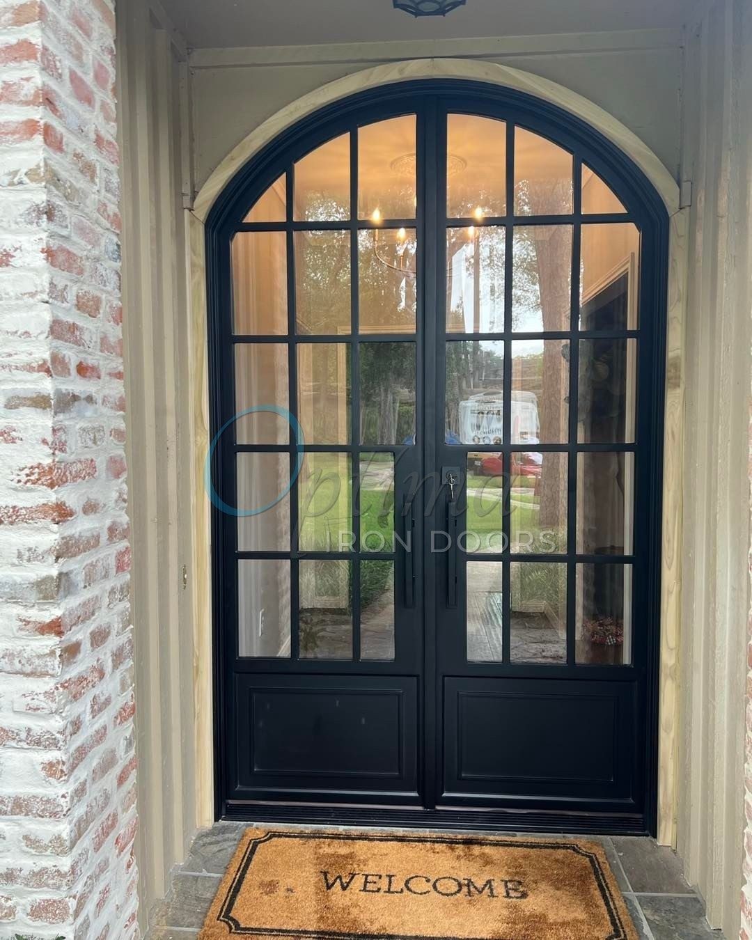 double iron doors with arch top and custom glass